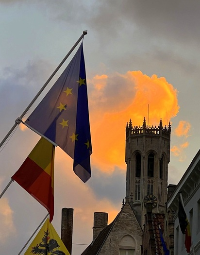 Flags flying near a tower at sunset