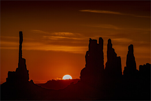 Vertical rocks framing a rising sun 
