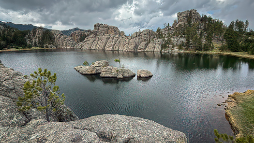 A calm lake surrounded by rocky cliffs