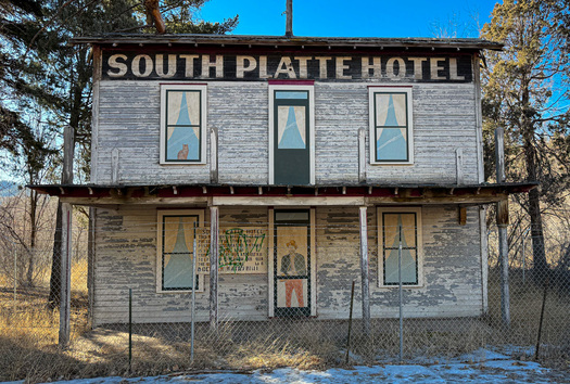 Dilapidated hotel with painted windows and door