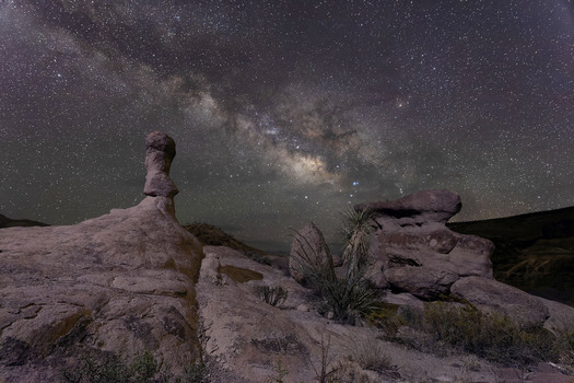 Hoodod rock formation at night with stars in ther background
