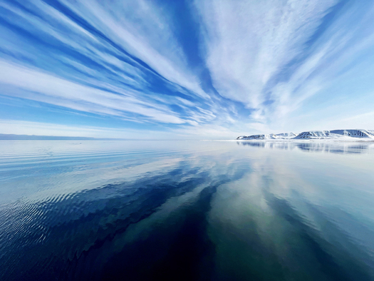 A stream of clowds reflected on water